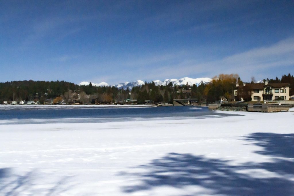 Image of Wayfarer's Park. Includes piece of Flathead Lake with the backside of Bigfork, MT in the background. There is a lot of snow on the ground.