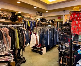 left side of Reloved Thrift Store of racks of clothing throughout that leads to a changing room and book room in the back